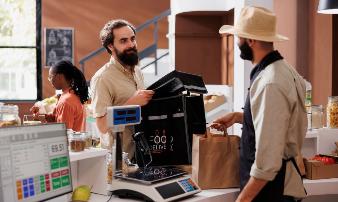 a man standing at a counter with a bag in front of him