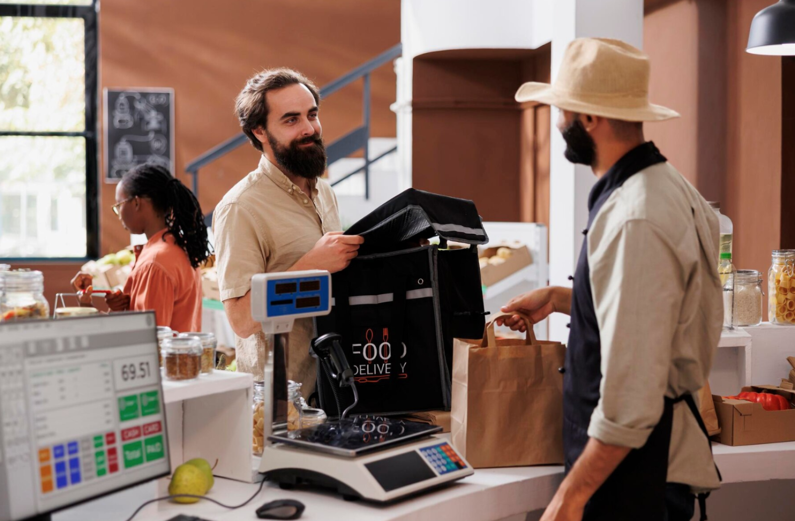 a man standing at a counter with a bag in front of him